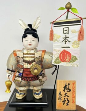 Esclusiva bambola giapponese “Momotarō” realizzata a mano con la pregiata tecnica kimekomi, con base e stendardo